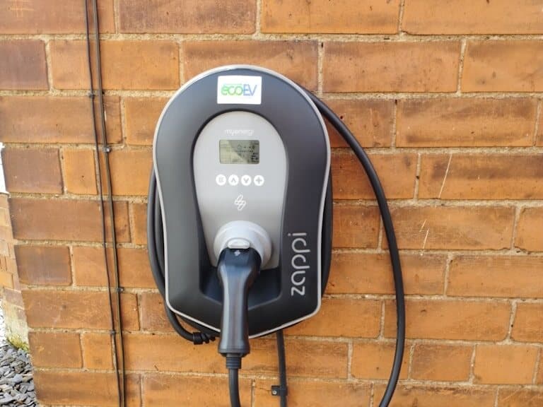 EV charger with its cable on a brick wall