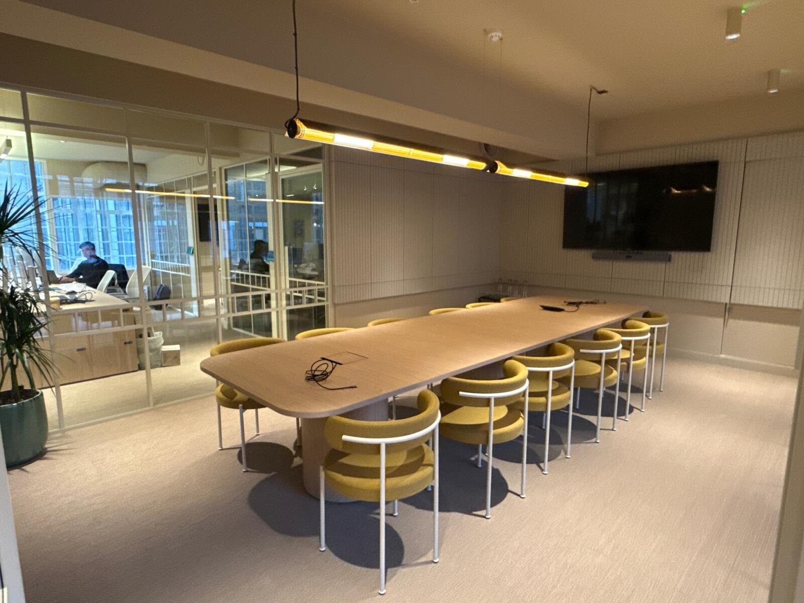 Office meeting room with long pendant lights over the table