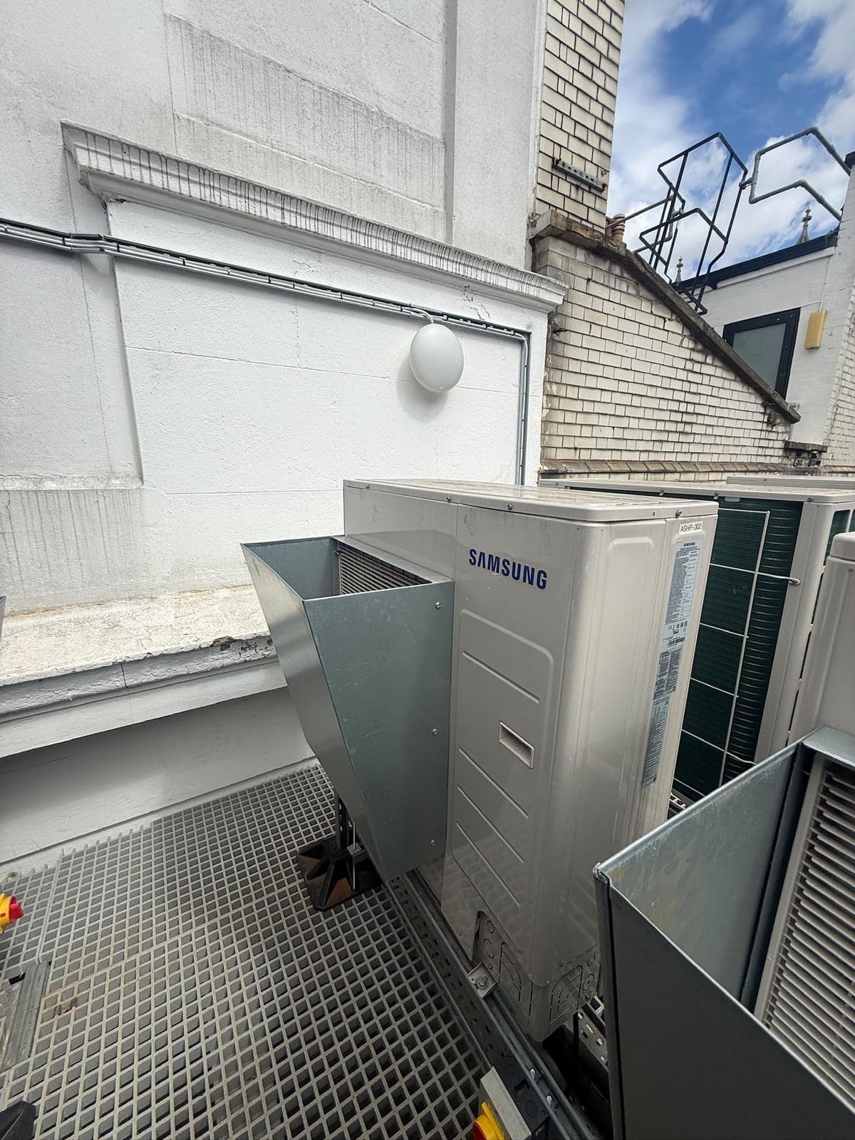 Rooftop air conditioning units with a bulkhead light and cable run on the wall