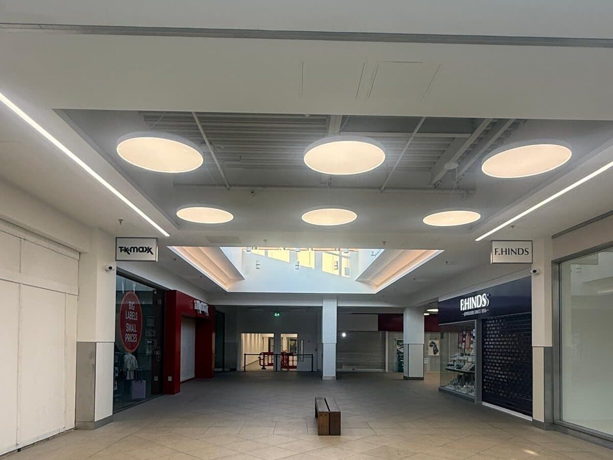 Round ceiling lights along a shopping centre walkway
