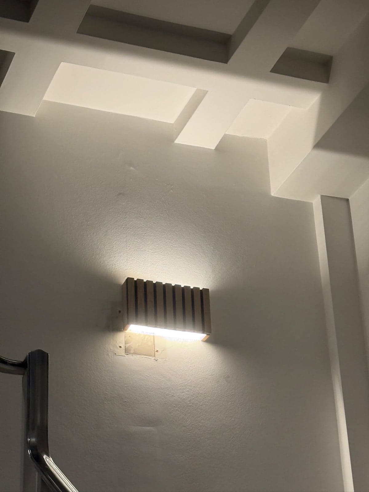 Slatted wall light washing a white stairwell wall